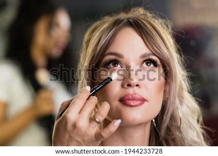 Similar – Image, Stock Photo Makeup artist doing makeup for young female artist