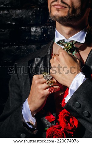 The young man is wizard corrects scarf and jewelry before performance