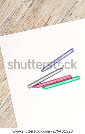 Pastels of blue, gray, red and green colors on a blank sheet of paper. Space for text. The concept of drawing and design.