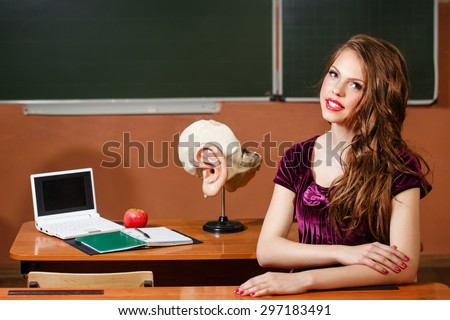 Excellent pupil sitting at a desk. On the table is a layout of the human ear, laptop, notebook and apple. The concept of modern education. Back to school.