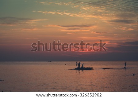 Big Game Fishing at sundown. Landscape of the ocean and sunset in the clouds. Unrecognizable people silhouettes. The concept of rest.
