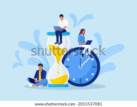 Tiny people and huge hourglass, alarm clock. Team working together with laptops. Time management and business planning. Time is money.  Deadline. Young employees work near the dial of a large watch.
