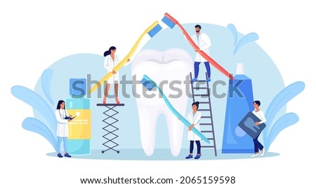 Stomatology, dentistry. Tiny Dentists standing around big tooth and cleaning, treating unhealthy teeth with caries cavity. Doctors brushing, clean plaque. Dental examination. Dentist appointment ストックフォト © 