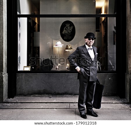 MILAN - MAY 3: Old gentleman with hat and pipe in front of Borsalino\'s shopwindow, most famous italian hats shop, May 3, 2013 in Milan, Italy.