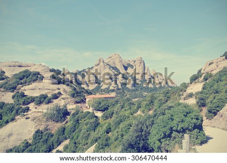 Rugged landscape of the Montserrat mountain, located close to Barcelona in Catalonia, Spain. Image filtered in faded, washed out, retro style with soft focus; nostalgic vintage travel concept.