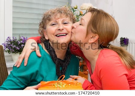 Mother is kissed by her daughter