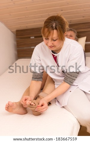 Nurse helps older woman in the bed