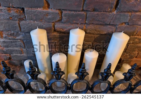 Various candles on a mantelpiece in restaurant