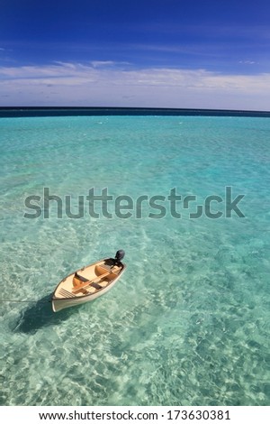 A small rowing boat drifting on an aqua blue sea at Gili Lankanfushi (formerly Soneva Gili) in the Maldives
