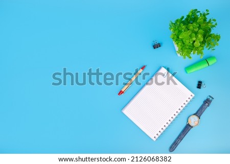 Office desk table with blank o clock, pen and green plant. Top view with copy space. Flat lay. Workspace concept. Education concept. Foto stock © 