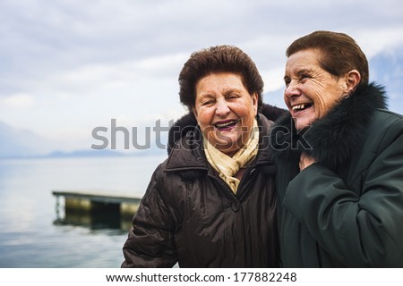 Affectionate senior women friends outdoors