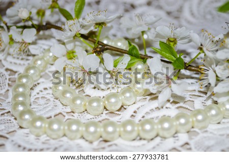 white spring cherry tree flower with pearls on lace background