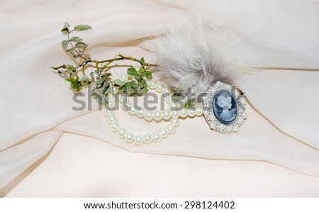 Vintage cameo with fur, dry rose branch and pearls
