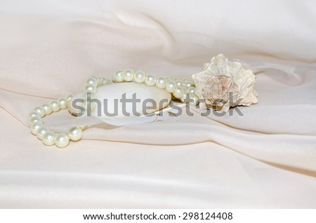 Vintage composition with pearls, shellfish, white sea stone and feather
