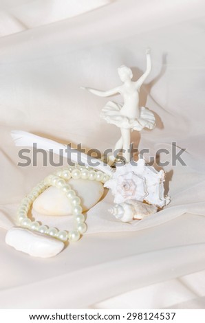 Vintage composition with  ballerina, pearls, shellfish, white sea stone and feather