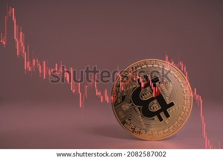 Closeup Bitcoin cryptocurrency upside down when Bitcoin price crash falling down, price, volume in stock market decrease for any risk with red trading price graph chart. Bitcoin price crash concept.