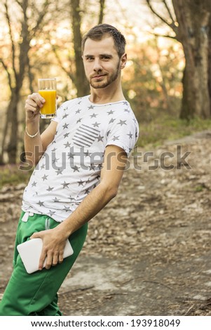 Young man drinking orange juice outdoor