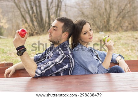 Happy Couple Eating Organic Apples in Autumn. Food.Outdoors.Park