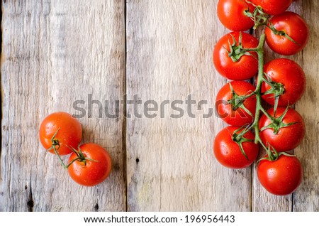 red cherry tomatoes on a white wood background. toning. selective focus on the right tomato