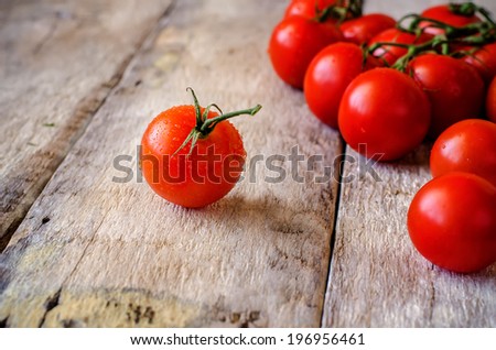 red cherry tomatoes on a white wood background. toning. selective focus on the tomato