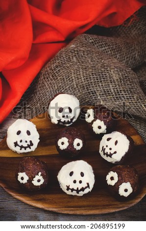 chocolate cakes in the form of monsters and skeletons for kids on Halloween dark wood background. toning. selective focus on the front middle skeleton