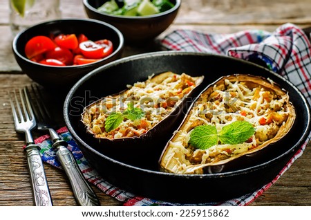eggplant stuffed with vegetables on a dark wood background. tinting. selective focus on mint