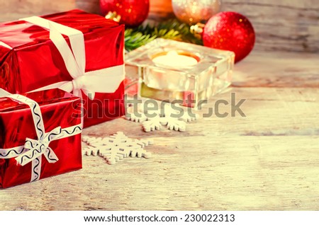 Christmas background with gifts, candle and balls on a light woody background. tinting. selective focus on gift