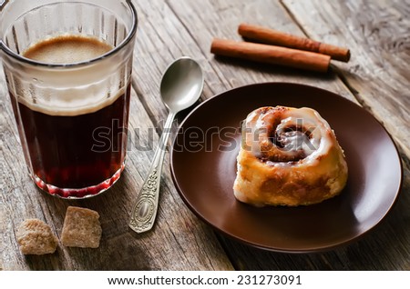 cinnamon rolls with cream icing on dark wood background. tinting. selective focus