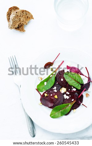 salad with roasted beets, goat cheese, mangold and pistachios on a white background. tinting. selective focus