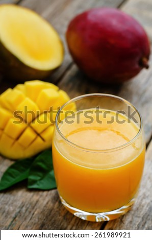 mango juice and fresh mango on a dark wood background. tinting. selective focus