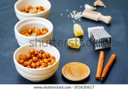 roasted chickpeas in different flavors on a black background. the toning. selective focus