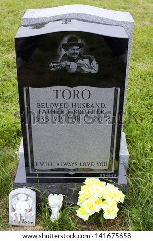 QUEENS, NEW YORK - JUNE 6: Grave of Yomo Toro, master of the Puerto Rican guitar like instrument called a cuatro.   Taken June 6, 2013 at Saint Michael\'s Cemetery in New York.