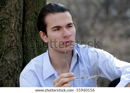 Male sitting outdoors in deep thought.  Photographed in Central Park in NYC.  he is in his twenties and has signed a model release. taken March, 2008