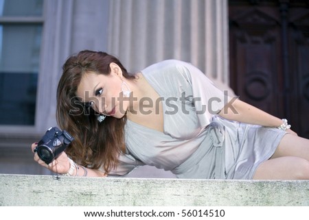 latin woman in her early twenties with camera.  She is from Bolivia and was photographed July, 2009 in the USA.
