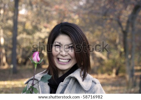 Asian girl with roses outdoors on a fall day.  She is of Japanese ethnicity and was 23 at the time of shoot.