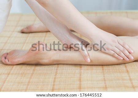 Foot massage for young lady in spa salon