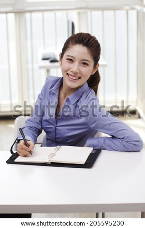 Businesswoman writing on portfolio