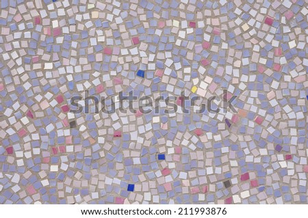 Mosaic of broken tile pieces on wall closeup