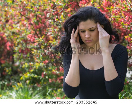 young woman in black shirt with headache