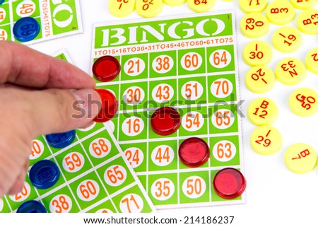 hand putting last chip to be winner of bingo game isolated on white background