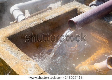 Hot water flowing out of pipe, hot spring water boiling, Beppu, Oita, Japan
