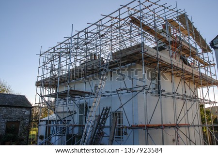 Scaffold with temporary roof being erected around a detached house, to allow building works and a re-roof to be carried out Stock foto © 