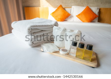 Set of hotel amenities (such as towels, shampoo, soap, drinking glass etc) on the bed. Hotel amenities is something of a premium nature provided in addition to the room when renting a room. Stock foto © 