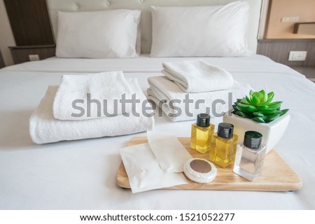Set of hotel amenities (such as towels, shampoo, soap, gel etc) on the bed. Hotel amenities is something of a premium nature provided in addition to the room when renting a room. Stock foto © 