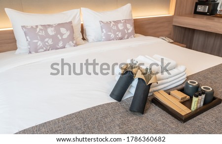 Set of hotel amenities (such as towels, shampoo, soap, toothbrush etc) on the bed. Hotel amenities is something of a premium nature provided in addition to the room when renting a room. Stock foto © 