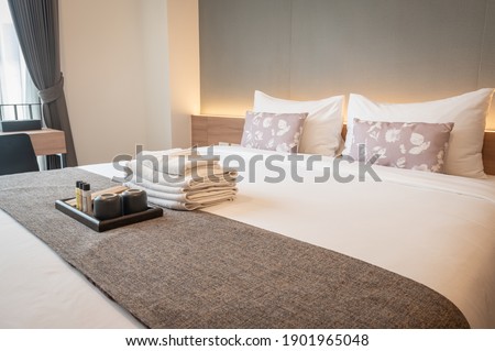 Side view of hotel amenities (such as towels, shampoo, soap, toothbrush etc) on the bed. Hotel amenities is something of a premium nature provided in addition to the room when renting a room. Stock foto © 