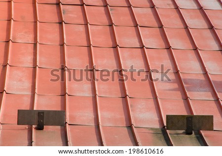 Old rusty metal orange roof on villa.