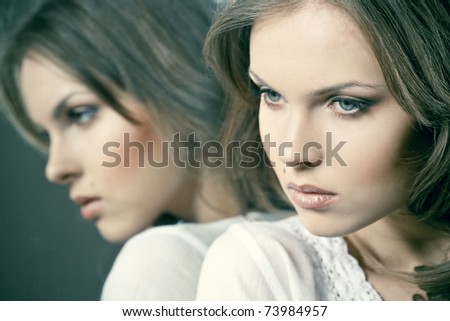 Beautiful young woman standing near a mirror