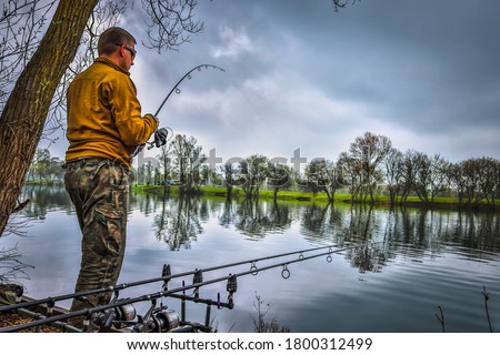 Fishing adventures, carp fishing. Angler is fishing with carp-fishing technique. 