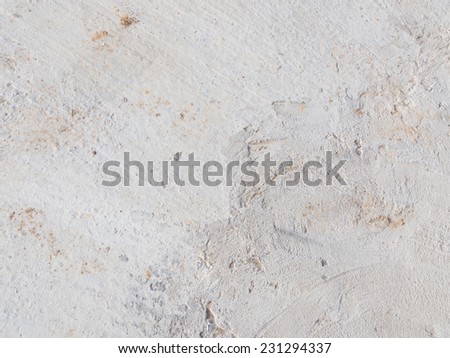 gray floor fresh concrete with small holes and dents stripes and orange sand crammed into them